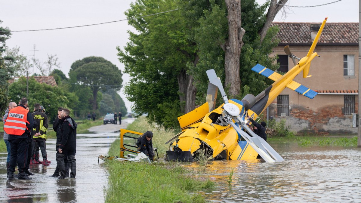 Mentőalakulatok tagjai vizsgálják a lezuhant mentőhelikopter roncsát a Ravenna tartományban fekvő Belricettóban 2023. május 20-án. A fedélzeten lévő mind a négy embert kórházba vitték, de csak az egyikük sérült meg. Emilia-Romagna tartományban a folyók, patakok áradása és az esőzés okozta földcsuszamlások miatt a legmagasabb fokozatú készültség van érvényben továbbra is. Az Olaszországot sújtó esőzések halálos áldozatainak száma 14-re emelkedett.