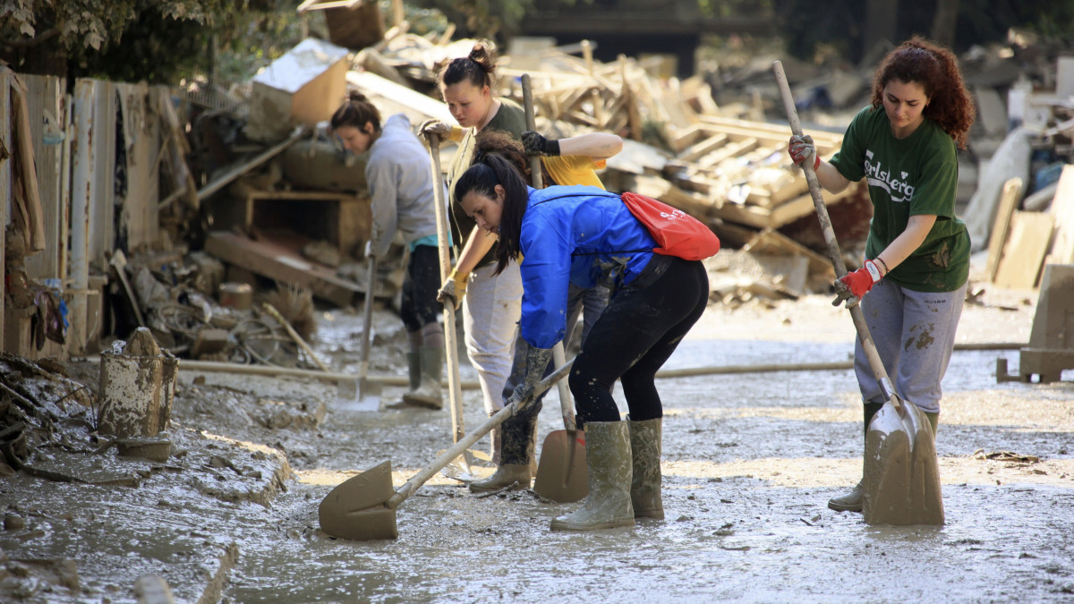 Sarat takarítanak el egy utcáról önkéntesek a közép-olaszországi Faenzában 2023. május 22-én, egy árvíz után. Az elsősorban Emilia Romagna tartományt sújtó áradások tizennégy ember halálát okozták, több mint tízezret pedig otthona elhagyására kényszerítettek.