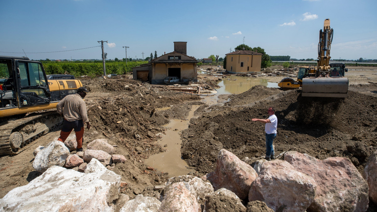 Munkagépekkel takarítják a hordalékot az árvíz sújtotta észak-olaszországi Ca di Lugóban 2023. május 23-án. Az elsősorban Emilia Romagna tartományt sújtó áradások tizennégy ember halálát okozták, több mint tízezret pedig otthona elhagyására kényszerítettek.