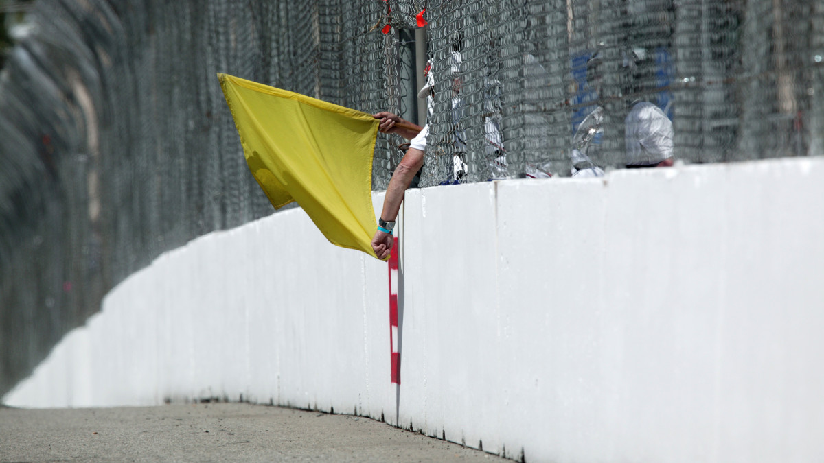 Yellow flag being held by saftey worker at race track. Shot with Canon 1Ds 400mm lens
