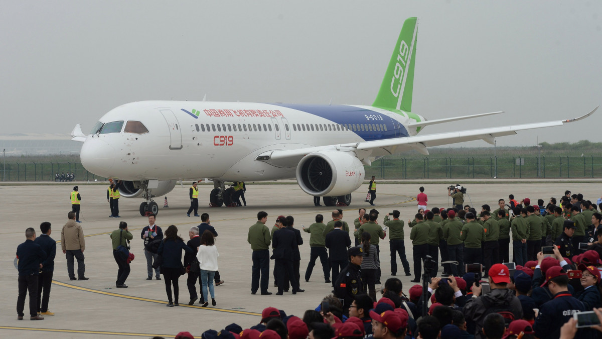 Az első kínai fejlesztésű és gyártmányú középkategóriás utasszállító repülőgépet, a C919-est köszöntik sikeres első próbarepülése után a sanghaji Putungi Nemzetközi Repülőtéren 2017. május 5-én. A Comac kínai állami vállalat gyártotta gép 158-168 utas szállítására alkalmas.