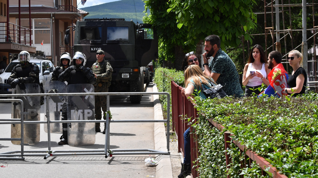 A NATO-parancsnokság alatt működő koszovói békefenntartó erő, a KFOR katonái és szerb lakosok a zvecani városháza előtt 2023. május 30-án. Az előző nap a KFOR 30 katonája, köztük 19 magyar, illetve 52 tüntető megsebesült a többségében szerbek lakta észak-koszovói városban kitört zavargásokban.
