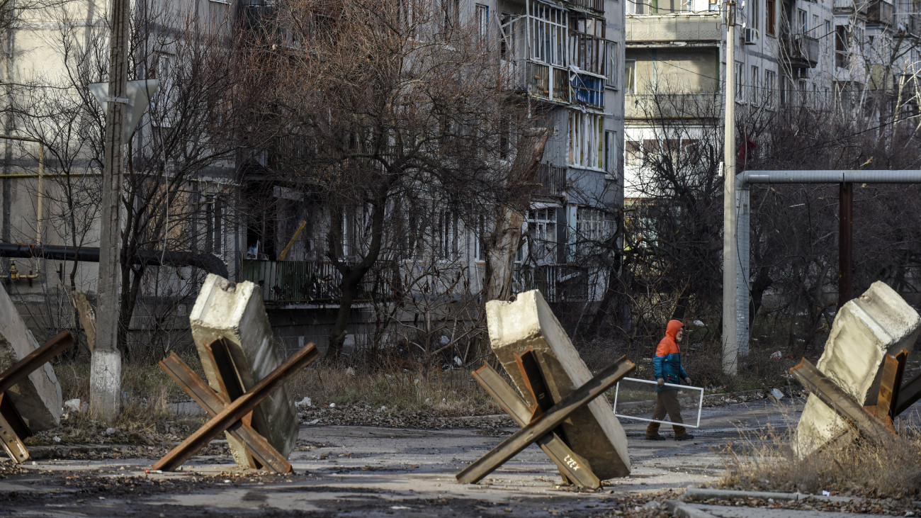 Járókelő megrongált lakóházak előtt, Bahmutban 2023. január 20-án. Az orosz erők ostroma miatt az ukrán hatóságok a kelet-ukrajnai Donyecki területen fekvő város kiürítésére szólították fel a lakosságot, ennek ellenére mintegy nyolcezren az otthonmaradást választották. A városban megszűnt a villany-, a gáz-, a vízszolgáltatás és a távfűtés.