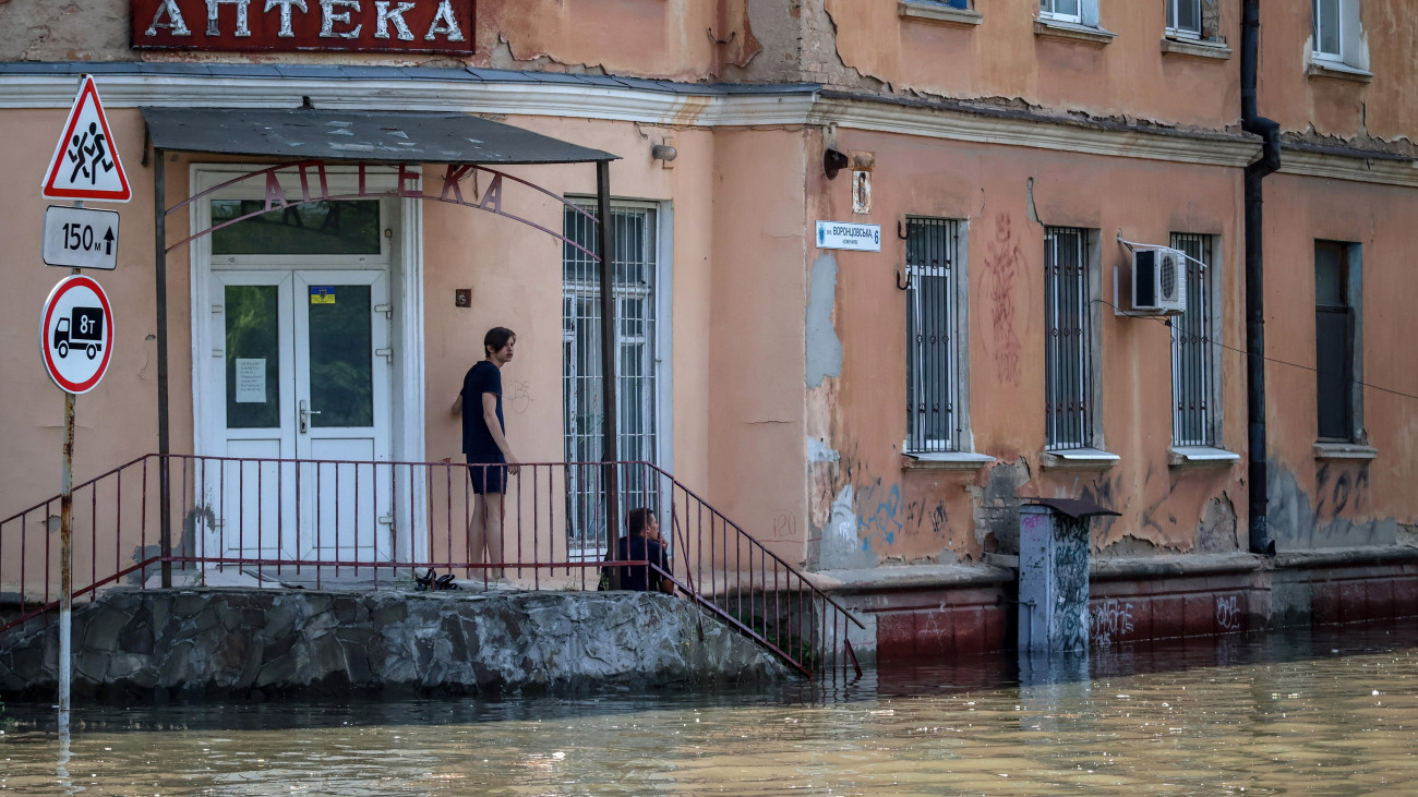 A gátrobbantás okozta árvizet nézi két férfi Herszonban 2023. június 7-én, egy nappal azután, hogy robbanás történt a dél-ukrajnai Herszoni területen lévő, jelenleg orosz ellenőrzés alatt álló Nova Kahovka-i víztározójának gátján. Az ukránok és az oroszok egymást vádolják a robbantás elkövetésével.