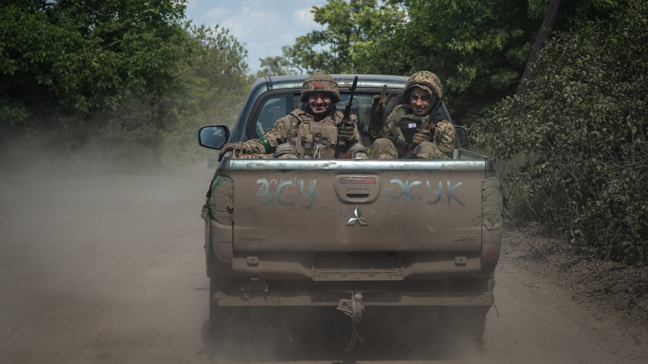 Ukrán katonák kisteherautón a kelet-ukrajnai Bahmut térségében húzódó fronton, az orosz erőkkel vívott harcok helyszínén 2023. június 5-én.