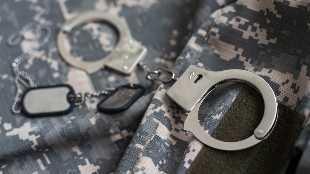military camouflage uniform, handcuffed on background