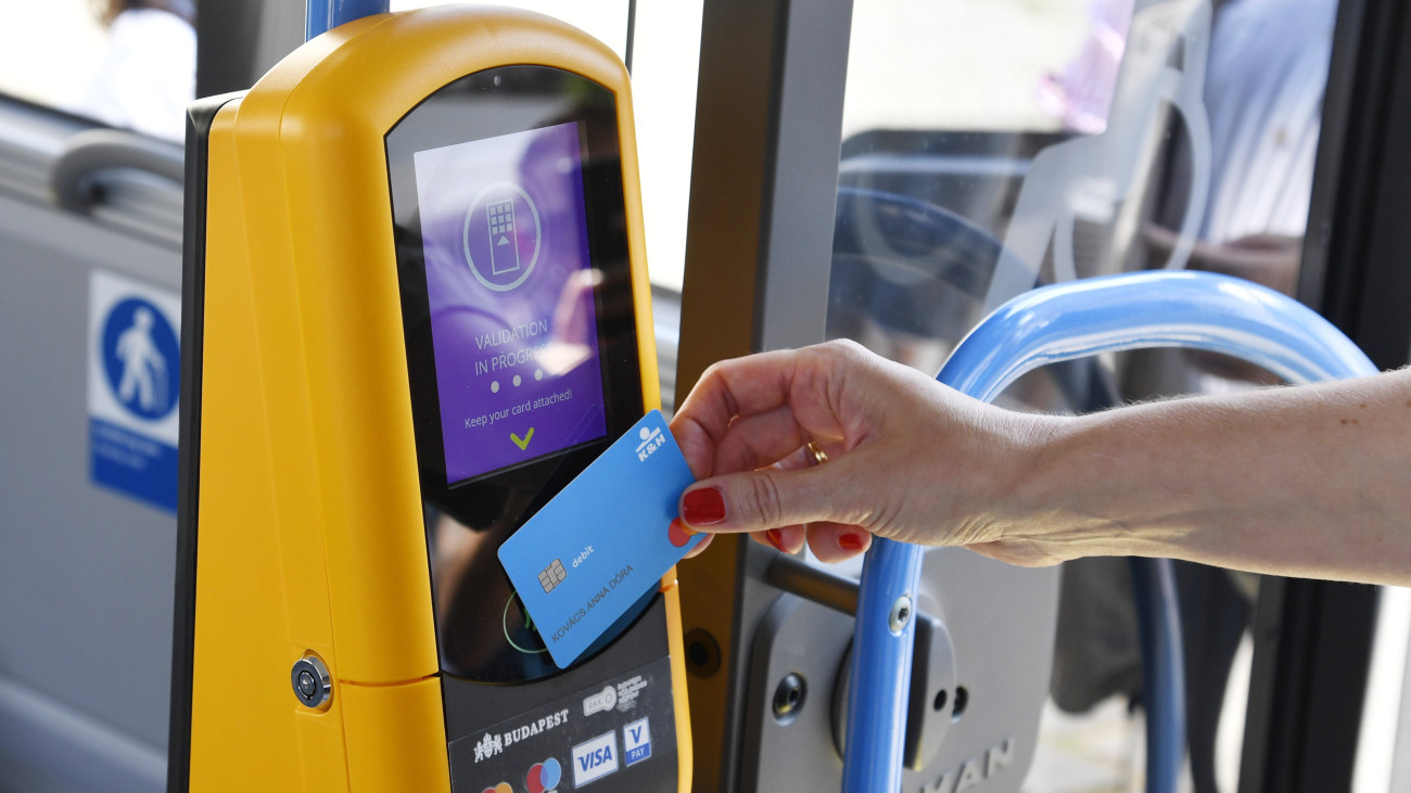 Tesztelik az új digitális jegyvásárlási és -érvényesítési rendszert Budapesten, a Városháza parkban 2023. június 20-án. A Budapest Pay&GO tesztidőszaka alatt a városközpont és a Liszt Ferenc-repülőtér között közlekedő 100 E buszjáraton bankkártyával vagy telefonnal is lehet jegyet venni.