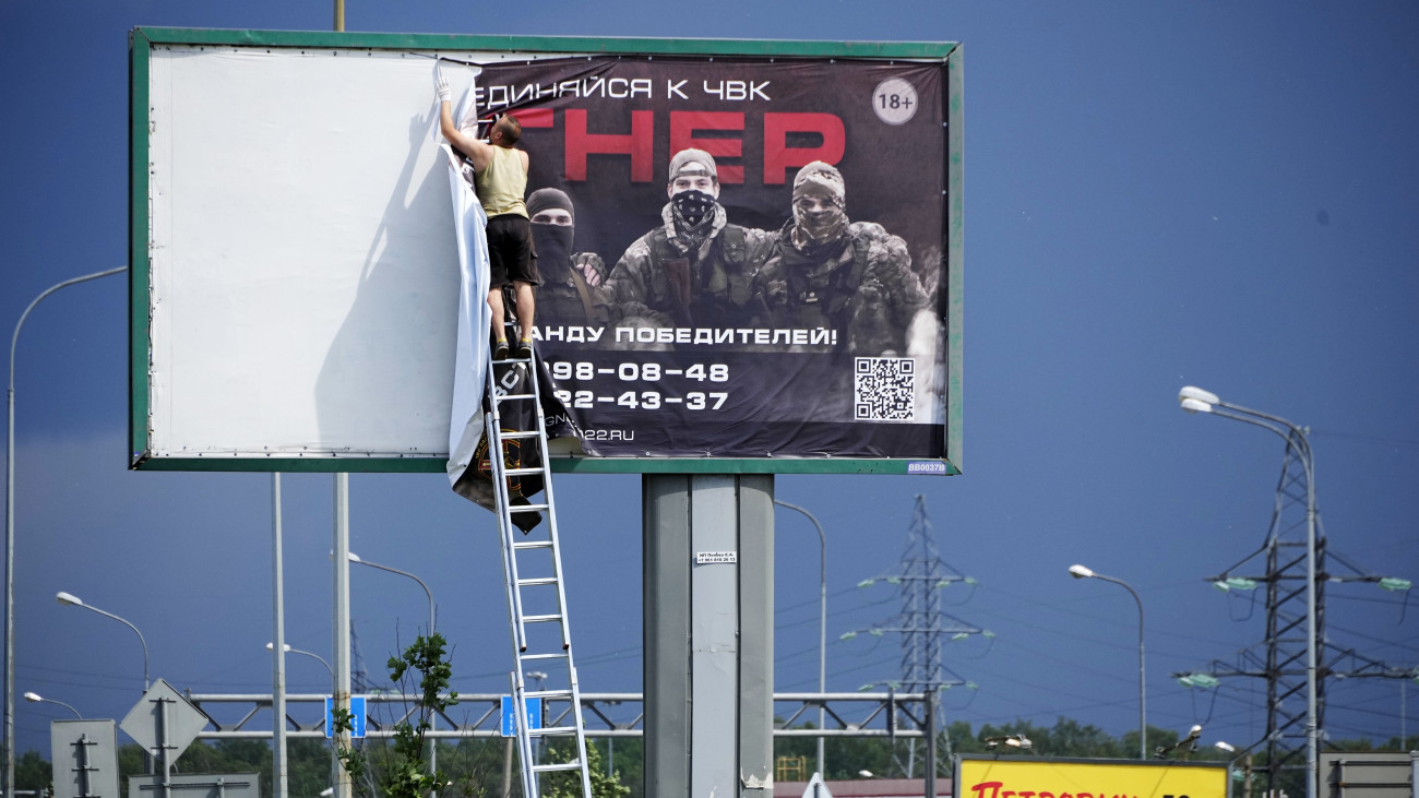 A Wagner-csoport nevű orosz zsoldoshadsereg egyik hirdetését távolítja el egy férfi Szentpéterváron 2023. június 24-én. Hajnalra nyílt katonai konfrontációvá fajult a Jevgenyij Prigozsin vezette Wagner-csoport és az orosz védelmi minisztérium viszálya. A magánhadsereg egységei legalább két helyszínen átléptek a megszállt ukrajnai térségekből Oroszország területére, és biztonsági szempontból kulcsfontosságú létesítményeket foglaltak el.