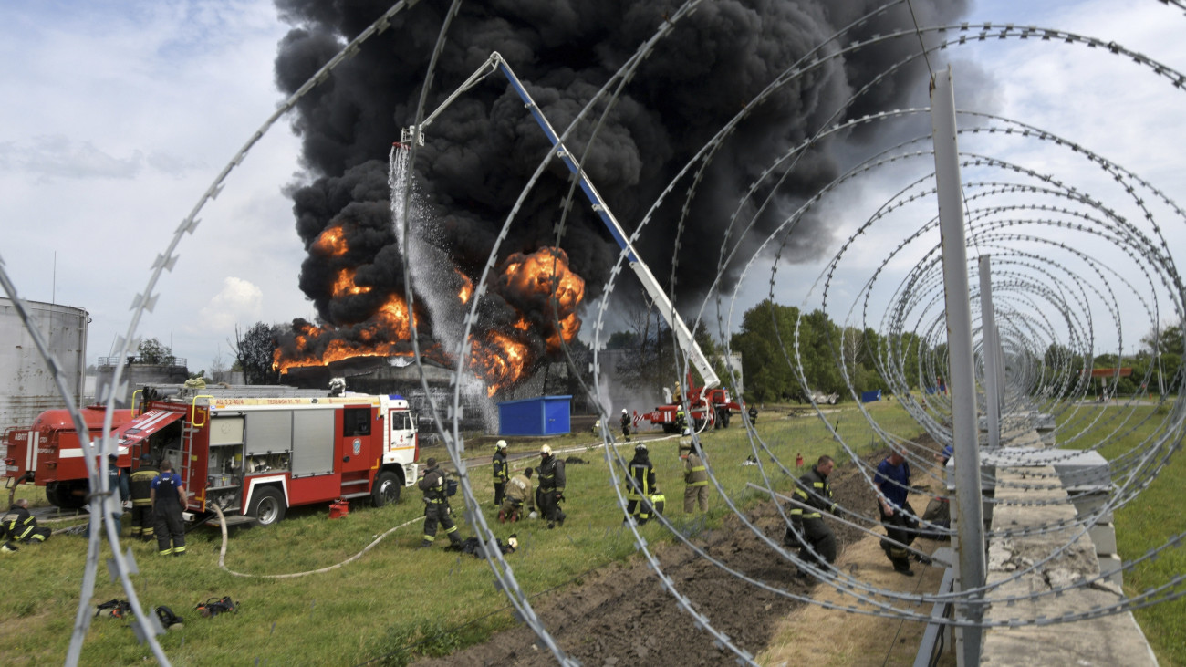 Tűzoltók küzdenek a lángok megfékezésén egy voronyezsi üzemanyagtárolót ért robbanás után 2023. június 24-én.