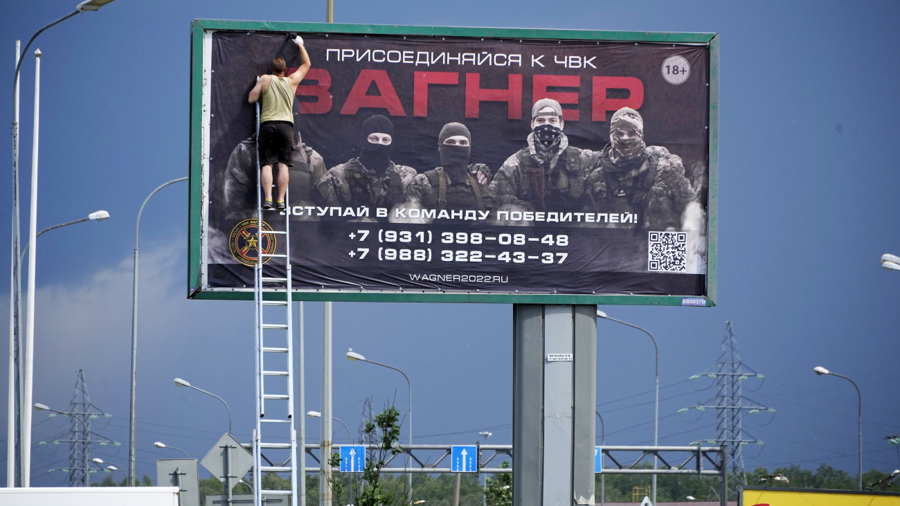 A Wagner-csoport nevű orosz zsoldoshadsereg egyik hirdetését távolítja el egy férfi Szentpéterváron 2023. június 24-én. Hajnalra nyílt katonai konfrontációvá fajult a Jevgenyij Prigozsin vezette Wagner-csoport és az orosz védelmi minisztérium viszálya. A magánhadsereg egységei legalább két helyszínen átléptek a megszállt ukrajnai térségekből Oroszország területére, és biztonsági szempontból kulcsfontosságú létesítményeket foglaltak el.