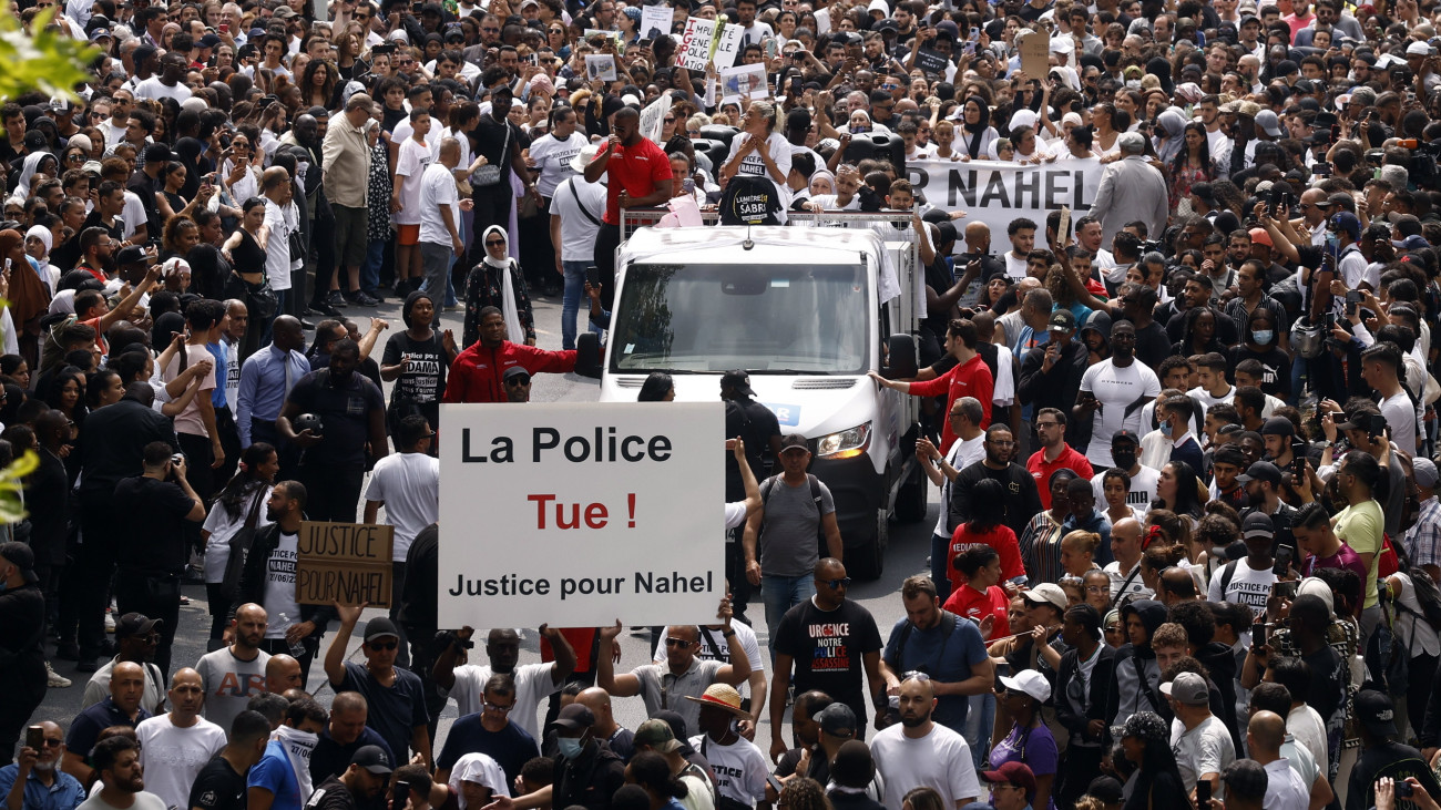 A rendőrök által lelőtt tinédzser halála miatt tiltakozó tüntetők vonulnak Párizs Nanterre nevű elővárosában 2023. június 29-én. Két nappal korábban egy közúti ellenőrzést végző francia rendőr intézkedés közben lelőtt egy 17 éves fiatalt a városban. A fiatal életét kioltó rendőrt kihallgatása után előzetes letartóztatásba helyezték, mivel az ügyészség szerint a buszsávban autót vezető fiú igazoltatásakor nem volt jogos a fegyverhasználat.