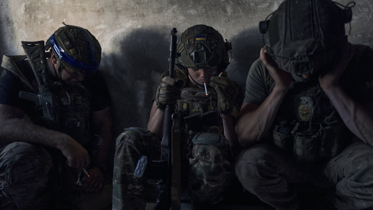 Ukrán katonák pihenőt tartanak bombázás alatt egy lakatlan épületben a frontvonalnál, a délkelet-ukrajnai Zaporizzsja térségében 2023. július 2-án, az orosz erőkkel vívott harcok idején.