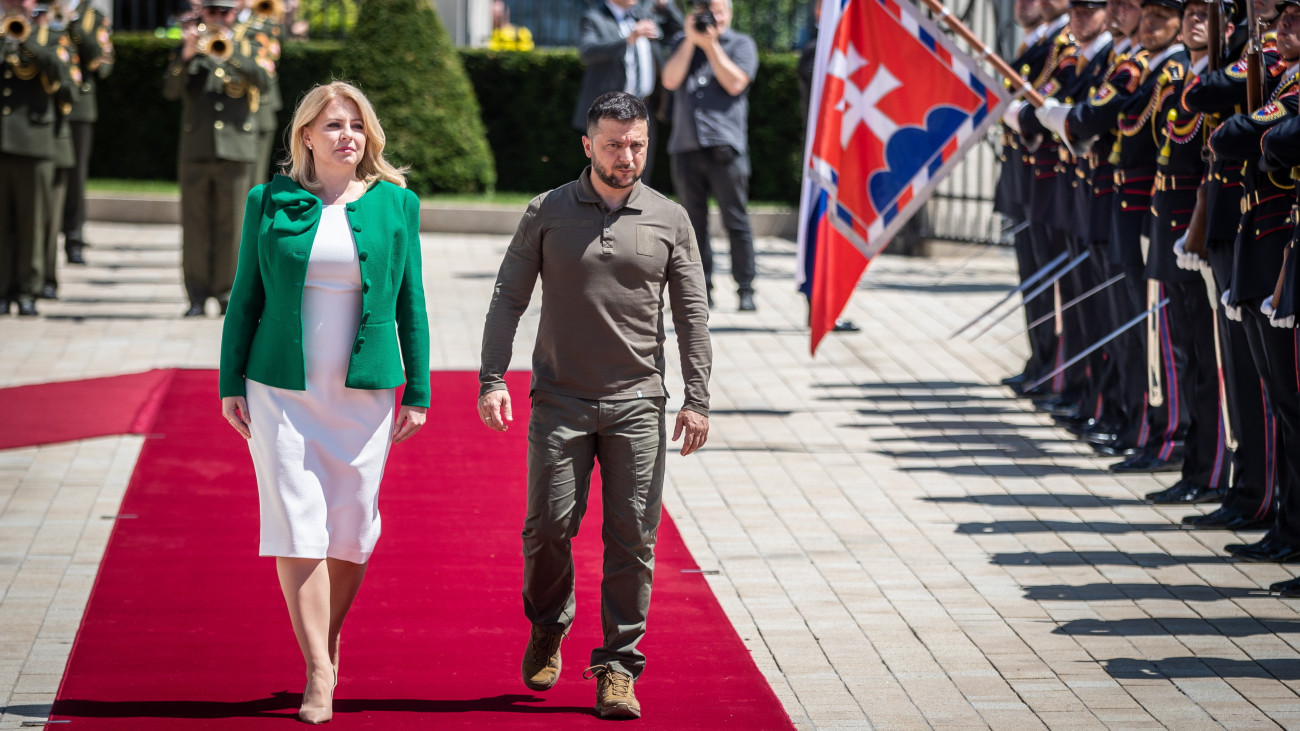 Zuzana Caputova szlovák államfő (b) és Volodimir Zelenszkij ukrán elnök ellép a díszsorfal előtt a pozsonyi elnöki palota előtt tartott fogadási ünnepségen 2023. július 7-én.