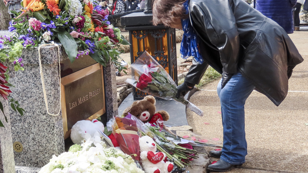 Virágot hagy egy nő Lisa Marie Presley amerikai énekesnő sírhelyénél a gyászszertartás után az énekesnő apja, Elvis Presley néhai amerikai énekes Graceland nevű birtokán Memphisben 2023. január 22-én. Lisa Marie, Elvis egyetlen gyermeke január 12-én, 54 éves korában hunyt el.
