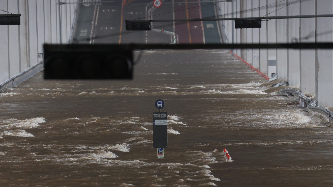 A monszunesők miatt megáradt Han folyó vize hömpölyög a Jamszu híd aszfaltburkolatán Szöulban 2023. július 14-én. Az özönvízszerű esőzések miatt reggelre virradóan több mint négyezer háztartás maradt áram nélkül a dél-koreai fővárosban.