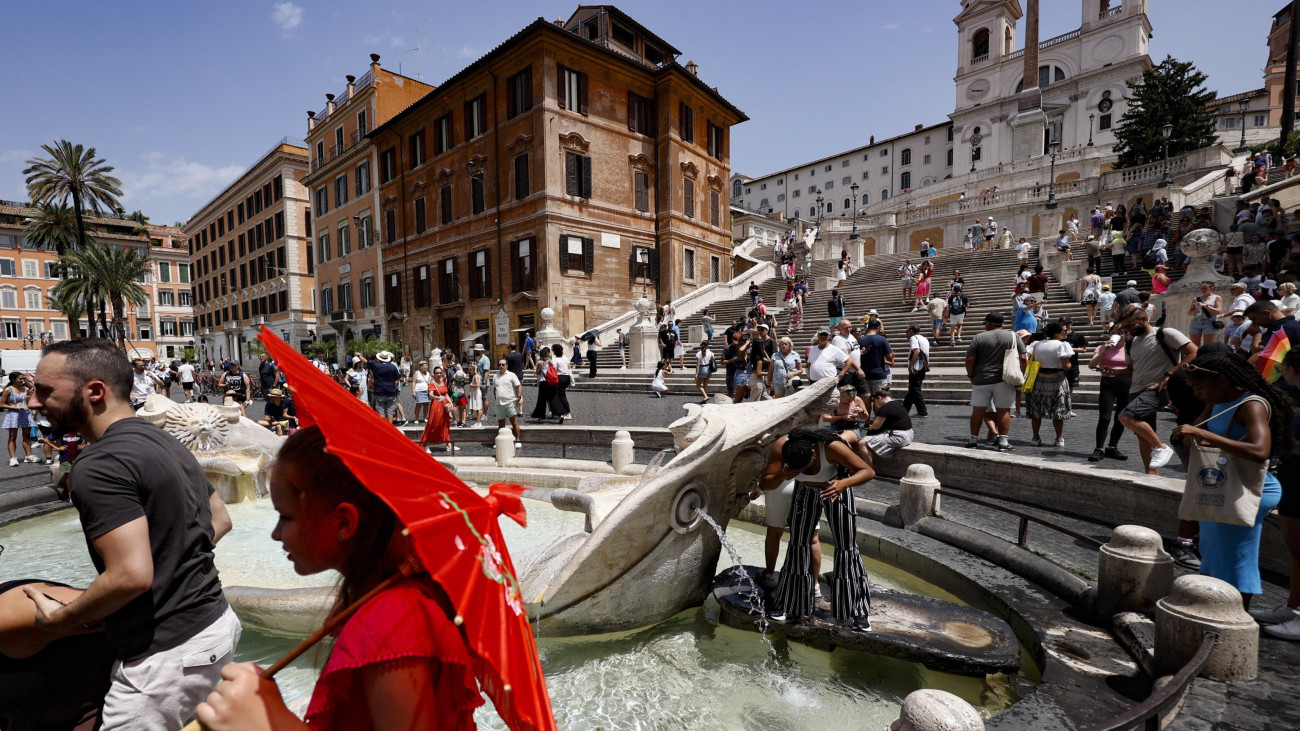 Turisták hűsítik magukat a római Spanyol lépcsővel szembeni szökőkút vizében 2023. július 8-án. Olaszország egyes részein a levegő hőmérséklete elérte a 45 Celsius-fokot.