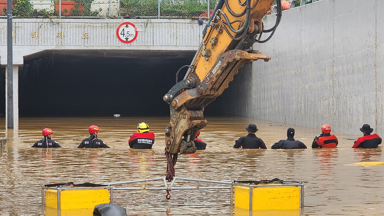 CHEONGJU, SOUTH KOREA - JULY 16: (EDITORIAL USE ONLY) In this handout image provided by the South Korea National Fire Agency, South Korean rescue workers searching for missing persons along a road submerged by floodwaters leading to an underground tunnel in flood waters after heavy rains on July 16, 2023 in Cheongju, South Korea. Flooding and landslides caused by heavy rains have killed at least 32 people nationwide and left more than 10 people missing while thousands evacuated their homes due to rain damage, authorities said. (Photo by South Korea National Fire Agency via Getty Images)