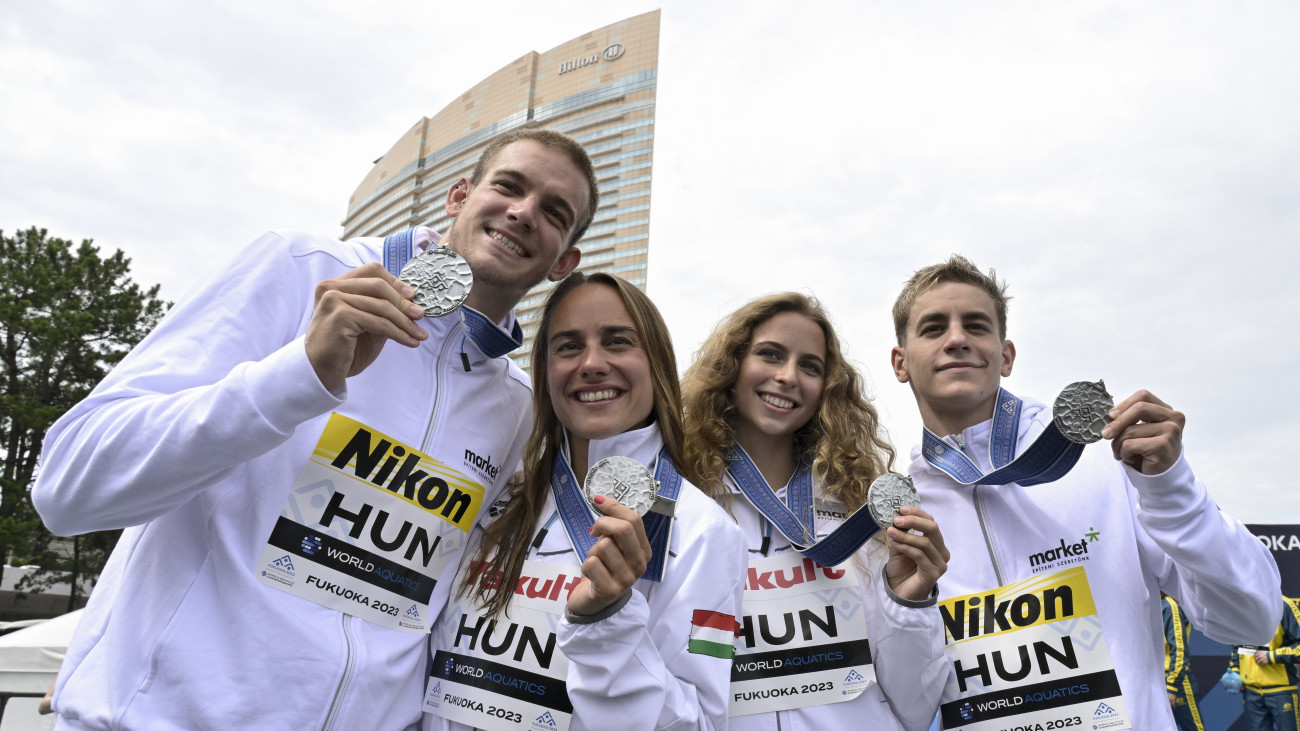 Rasovszky Kristóf, Olasz Anna, Fábián Bettina és Betlehem Dávid (b-j), az ezüstérmes magyar váltó tagjai a nyílt vízi úszók 4x1500 méteres csapatversenyének eredményhirdetése után a fukuokai vizes világbajnokságon 2023. július 20-án.