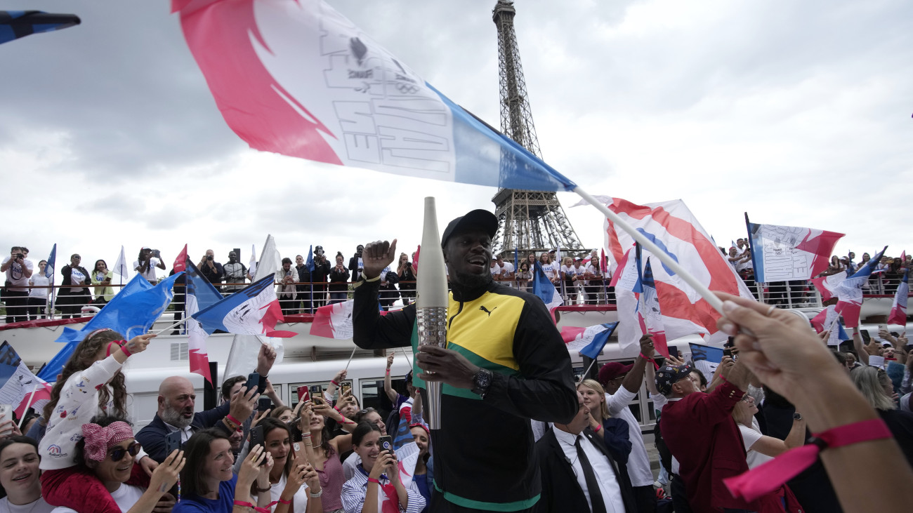 Usain Bolt olimpiai és világbajnok jamaicai atléta kezében a 2024-es párizsi olimpia fáklyájával az ötkarikás játékok fáklyaváltójának befejezése alkalmából rendezett eseményen a francia fővárosban 2023. július 25-én.