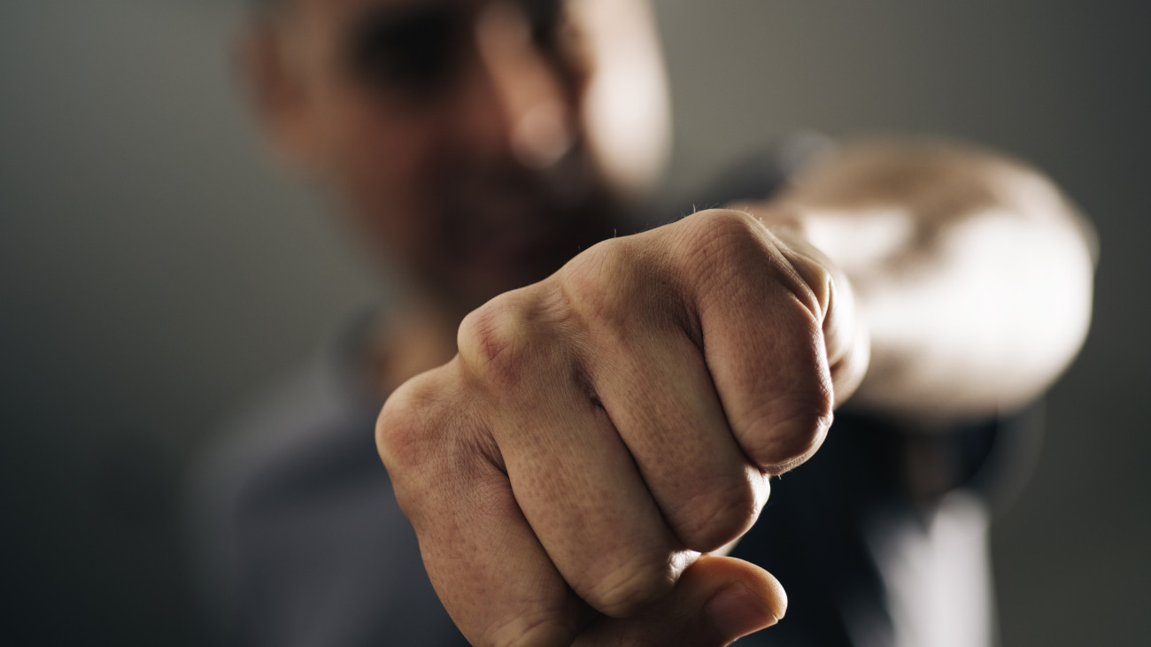 closeup of a young caucasian man throwing a punch to the observer, with a dramatic effect