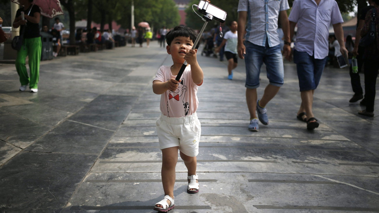 Peking, 2015. június 1.Kínai kisfiú önmagát fényképezi okostelefonnal a pekingi Tiltott Városban gyermeknapon, 2015. június 1-jén. Az egyébként hétfőnként zárva tartó Tiltott Város a nemzetközi gyermeknap alkalmából most nyitva van, és ingyen fogadja a tizennégy év alatti gyerekeket. (MTI/EPA/Hou Hvi Jang)