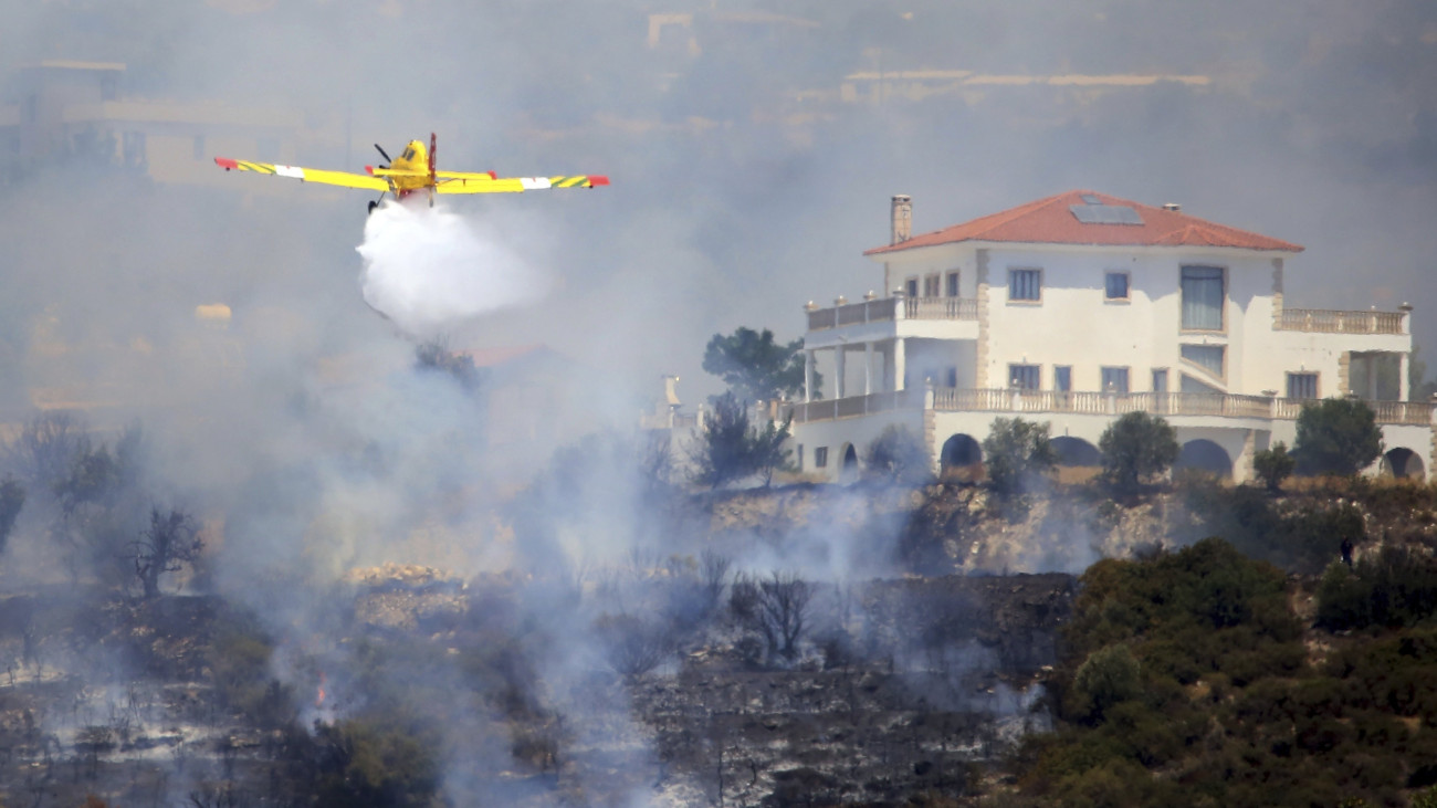 Erdőtüzet oltanak repülőgéppel a ciprusi Limasszol közelében fekvő faluban, Apesziában 2023. augusztus 7-én. Görögország két tűzoltó repülőgépet küldött Ciprusra, ahol több négyzetkilométernyi hegyvidéket perzseltek fel a lángok augusztus 4. óta.