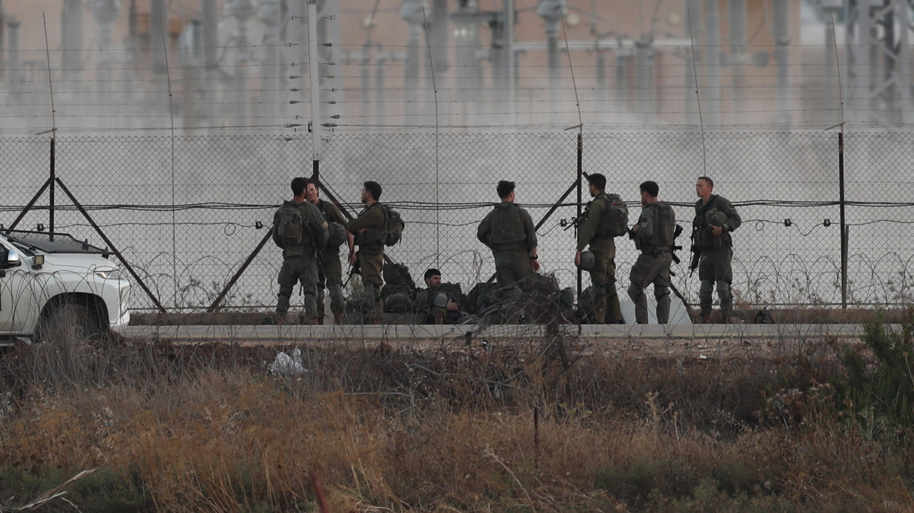 Izraeli katonák a ciszjordániai Dzsenínben levő palesztin menekülttábor kerítésénél 2023. július 4-én. Az izraeli hadsereg terrorista célpontok ellen végrehajtott támadásában két nap alatt tizenkét palesztin vesztette életét, tucatnyian megsebesültek és több ezer palesztin civil elhagyta a városban lévő menekülttábort. Izrael lezárta a kétnapos akciót, amely során a hadsereg közlése szerint ezernél több robbanószerkezetet semmisítettek meg, több tucat fegyvergyártó műhelyben okoztak kárt, és harminc palesztin gyanúsítottat letartóztattak.