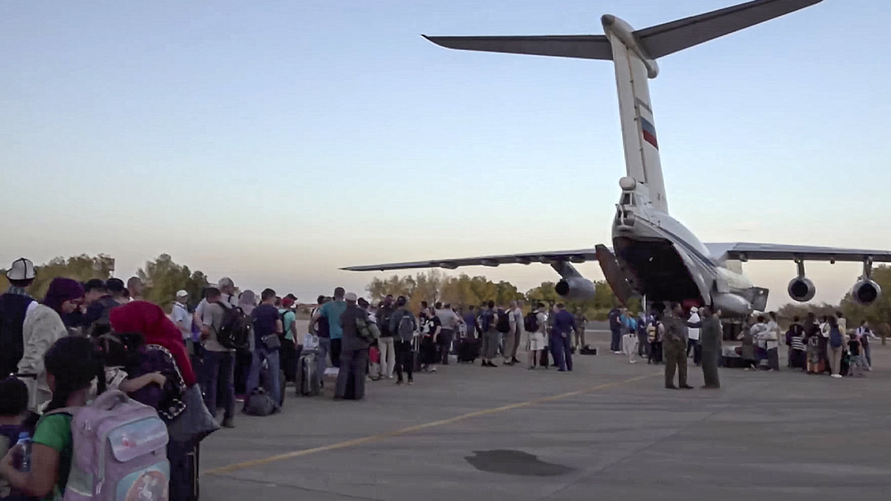 Az orosz védelmi minisztérium által közreadott videóról készített képen kimenekítendő polgári személyek szállnak be egy orosz gépbe a szudáni főváros, Kartúm repülőterén 2023. május 2-án. A Szudánban dúló harcok miatt az orosz hadsereg négy Il-76-os repülőgépe több mint 200, többségében orosz állampolgárt szállított el a szudáni fővárosból.