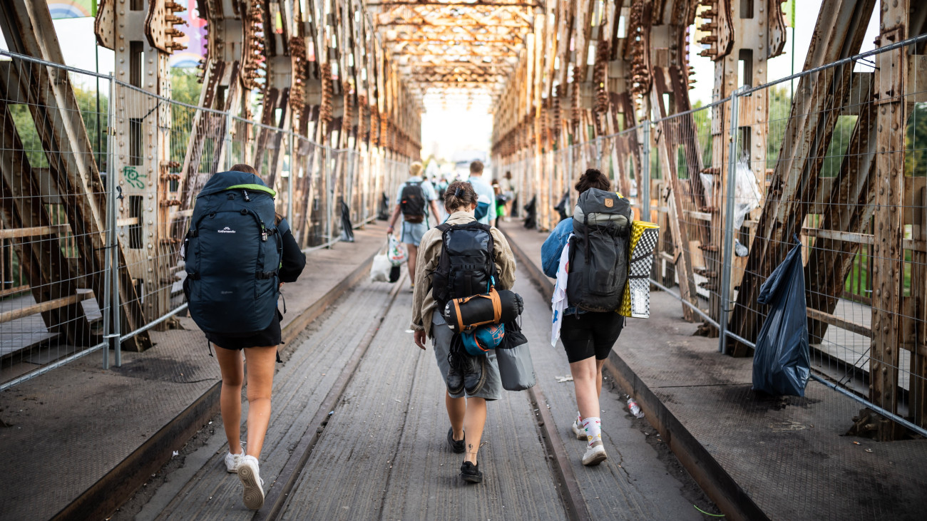 A befejeződött 29. Sziget Fesztiválról távozó fiatalok az óbudai Hajógyári-szigetre vezető K-hídon 2023. augusztus 16-án.