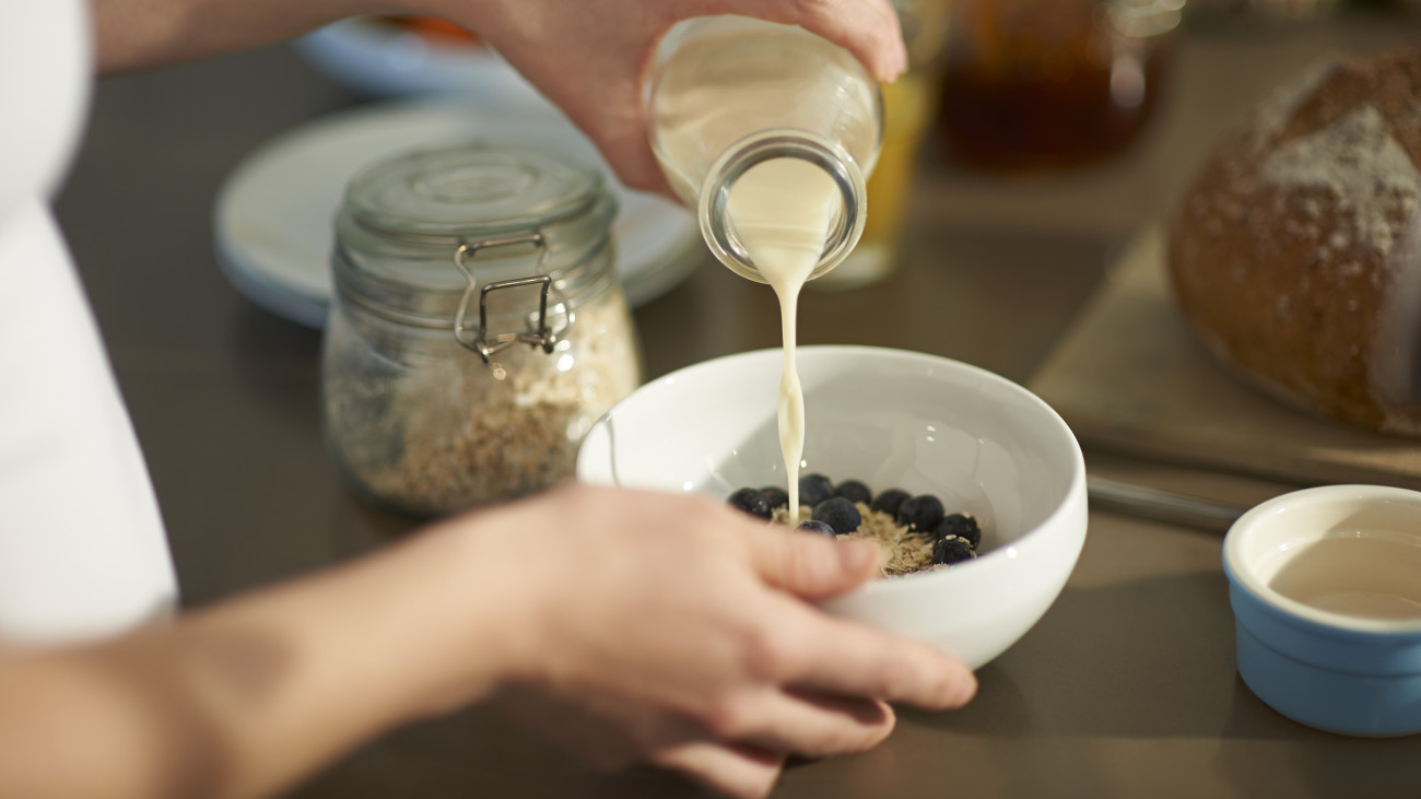 A woman prepares a wholesome breakfast of oats, fresh berries and milk in a zero waste kitchen.