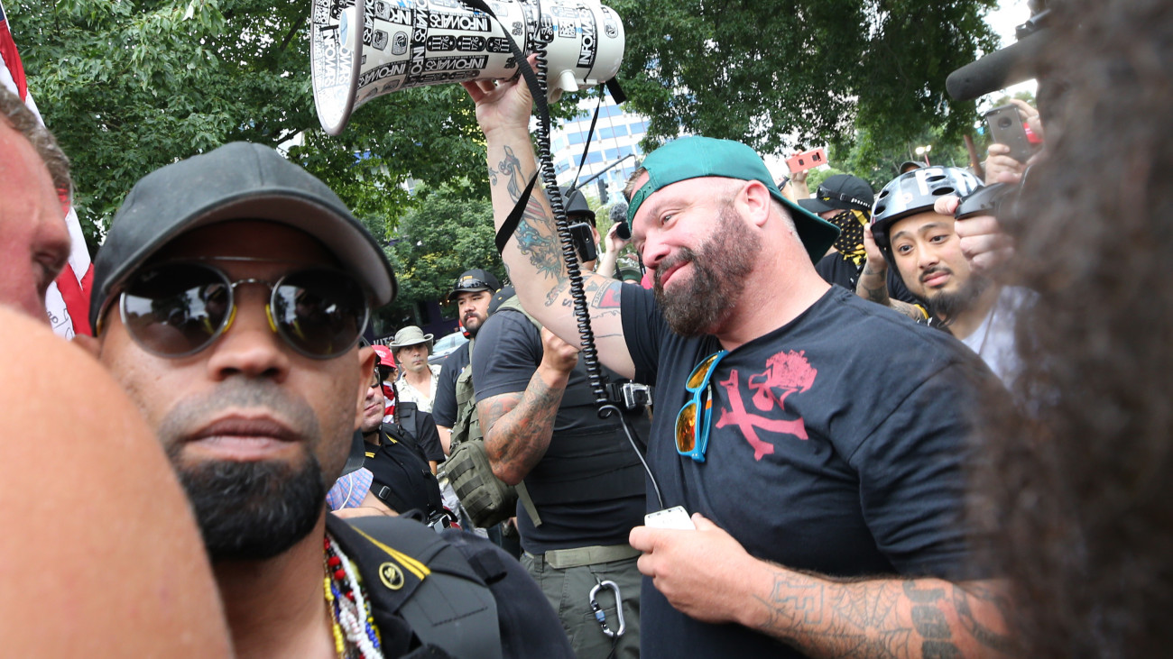 PORTLAND, OR - AUGUST 17: Joe Biggs (C), leader of the alt-right group, Proud Boys, and Enrique Tarrio (L), Chairman of the Proud Boys, speak to their followers during the End Domestic Terrorism rally at Tom McCall Waterfront Park on August 17, 2019 in Portland, Oregon. Anti-fascism demonstrators gathered to counter-protest a rally held by far-right, extremist groups. (Photo by Karen Ducey/Getty Images)