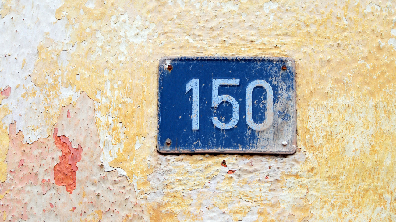 House address plate number (150) hanging on wall