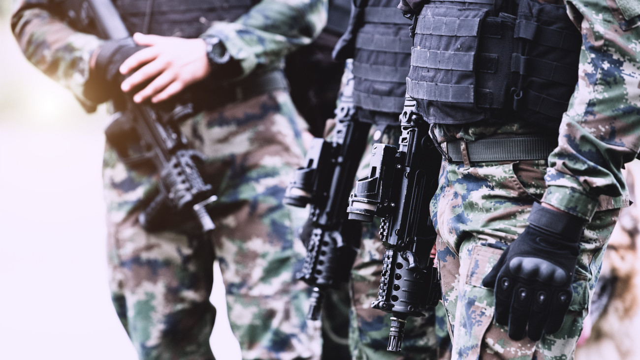 A salvadoran soldiers hand holding an M16 rifle.