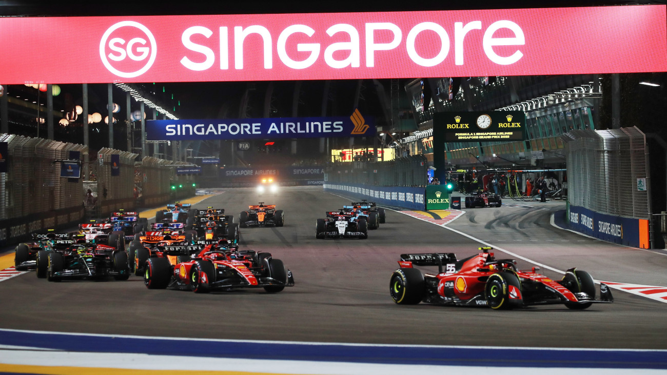 Carlos Sainz, a Ferrari spanyol versenyzője vezet monacói csapattársa, Charles Leclerc előtt a Forma-1-es autós gyorsasági világbajnokság Szingapúri Nagydíján a Marina Bay utcai pályán 2023. szeptember 17-én.