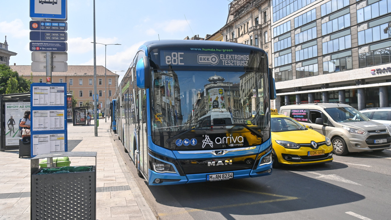 Tesztüzemben közlekedő MAN Lions City 18 E típusú, elektromos meghajtású csuklós autóbusz a Blaha Lujza téren 2023. augusztus 4-én. A 18 méter hosszú, négyajtós, 130 ember befogadására képes buszt augusztus 11-ig próbálhatják ki az utasok a belvárost is átszelő 8E vonalon. Az Arrivabus üzemeltetésében közlekedő jármű egy töltéssel 350 kilométert tud megtenni, akkumulátorait négy óra alatt lehet teljesen feltölteni.