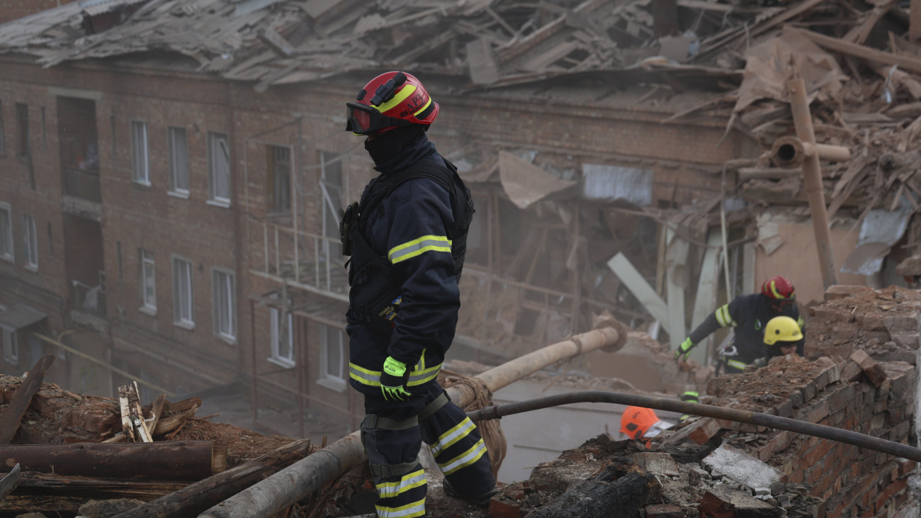 Orosz légitámadásban megsérült lakóház romjai között keresnek áldozatokat mentők a kelet-ukrajnai Harkivban 2023. október 6-án.