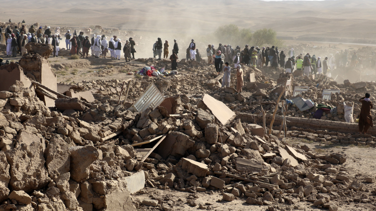 Afgán férfiak túlélőket keresnek az előző napi földrengés után a nyugat-afganisztáni Herát tartomány egyik településén, Zenda Janban 2023. október 8-án. A hivatalos adatok szerint több mint kétezer ember halt meg az előző napi heves földrengésben Afganisztán nyugati részén.