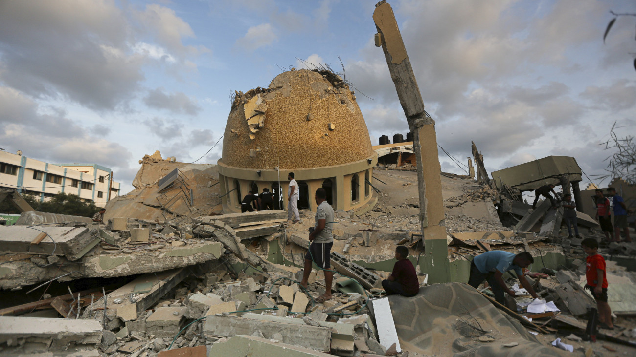 Izraeli légicsapásokban megrongálódott mecsetet néznek emberek a Gázai övezetben lévő Hán-Júniszban 2023. október 8-án. Előző nap a Hamász palesztin iszlamista szervezet rakétaáradatot zúdított Izrael déli és középső részére a Gázai övezetből, és több tucat fegyverese hatolt be izraeli településekre. Az izraeli hadsereg ezután ellencsapásokat hajtott végre délen a Gázai övezetet uraló iszlamista Hamász és Iszlám Dzsihád terrorszervezet ellen, valamint északon a libanoni határnál.