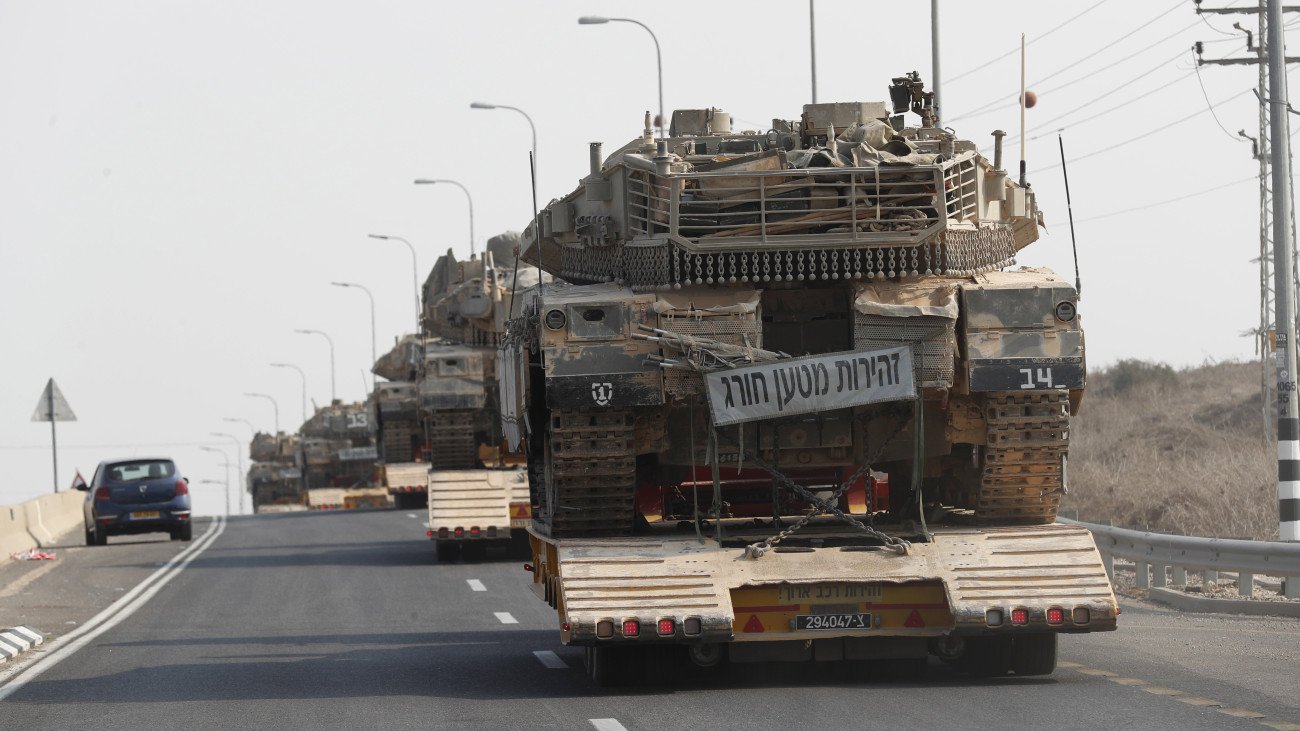 Az izraeli hadsereg tankokat szállít a Gázai övezet határa felé, a dél-izraeli Szderót közelében 2023. október 8-án. Előző nap a Hamász palesztin iszlamista szervezet rakétaáradatot zúdított Izrael déli és középső részére a Gázai övezetből, és több tucat fegyverese hatolt be izraeli településekre. Az izraeli hadsereg ezután ellencsapásokat hajtott végre délen a Gázai övezetet uraló iszlamista Hamász és Iszlám Dzsihád terrorszervezet ellen, valamint északon a libanoni határnál.
