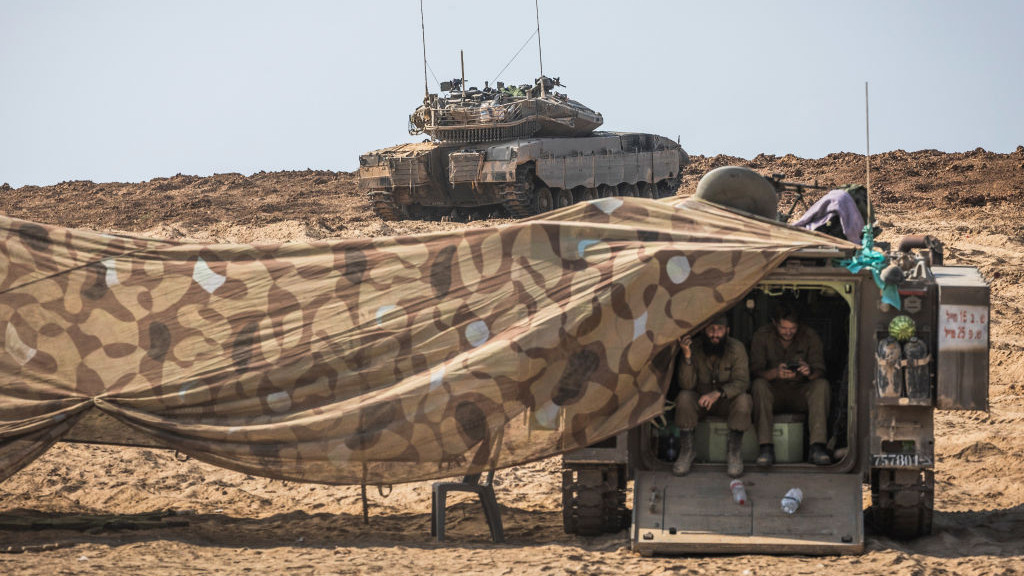 14 October 2023, Israel, Beeri: Israeli soldiers take cover inside a military vehicle near the Israeli-Gaza border as fighting between Israeli troops and the militants of the Palestinian group Hamas continues. Photo: Ilia Yefimovich/dpa (Photo by Ilia Yefimovich/picture alliance via Getty Images)