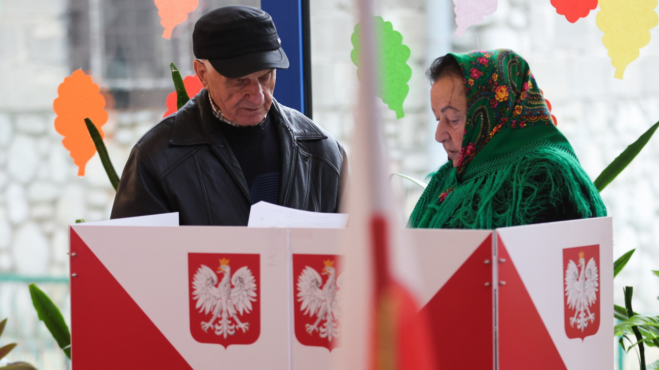 Tátrai házaspár szavaz a lengyel parlamenti választásokon a Zakopane közelében fekvő faluban, Zabban 2023. október 15-én. A választásokkal egy időben népszavazást is rendeznek az Európai Unió migrációs csomagjáról, az állami vagyon privatizációjáról, a nyugdíjkorhatárról, valamint a fehérorosz határon emelt acélkerítésről.