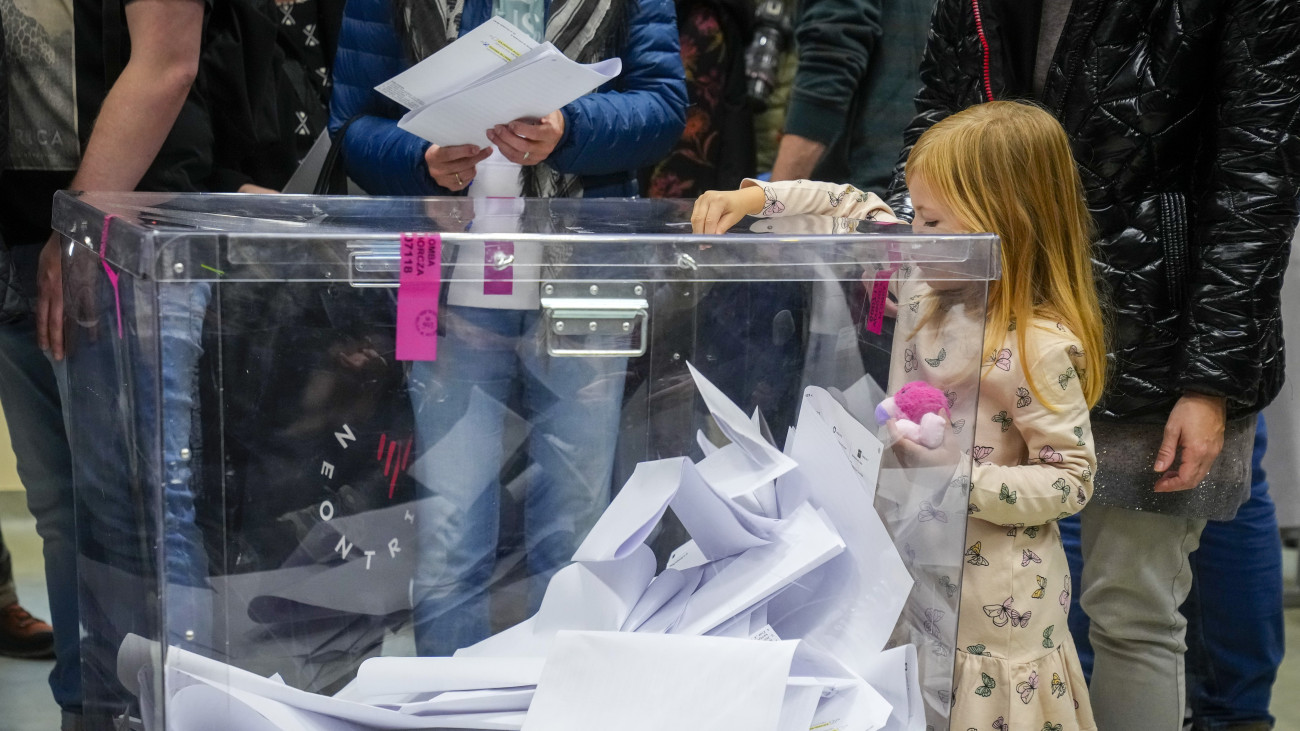 Kislány dob be szavazólapot a lengyel parlamenti választásokon Varsóban 2023. október 15-én. A választásokkal egy időben népszavazást is rendeznek az Európai Unió migrációs csomagjáról, az állami vagyon privatizációjáról, a nyugdíjkorhatárról, valamint a fehérorosz határon emelt acélkerítésről.