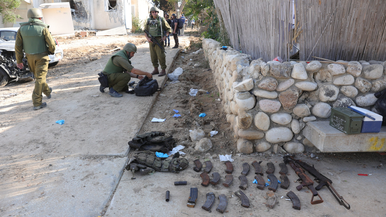 Izraeli katonák palesztin fegyverek mellett, a Gázai övezetet irányító Hamász palesztin iszlamista szervezet Izrael ellen október 7-én indított többfrontos támadásakor lerohant dél-izraeli Kefar-Aza kibucban 2023. október 15-én. A palesztin milicisták több mint 1300 embert megöltek Izraelben.