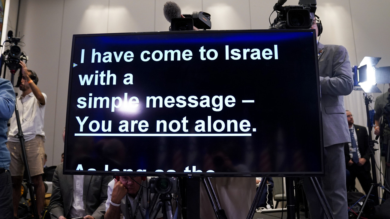 Súgógép, miközben Joe Biden amerikai elnök beszél az Izrael és a Hamász palesztin iszlamista szervezet háborújával kapcsolatban Tel-Avivban egynapos izraeli látogatásának végén, 2023. október 18-án. A szöveg jelentése: Egyszerű üzenettel jöttem Izraelbe - Nem vagytok egyedül. A Gázai övezetet irányító Hamász október 7-én többfrontos támadást indított Izrael ellen, ahol legalább 1400 ember életét vesztette. A Hamász elleni izraeli válaszcsapások több mint 3300 palesztin halálát okozták a Gázai övezetben.