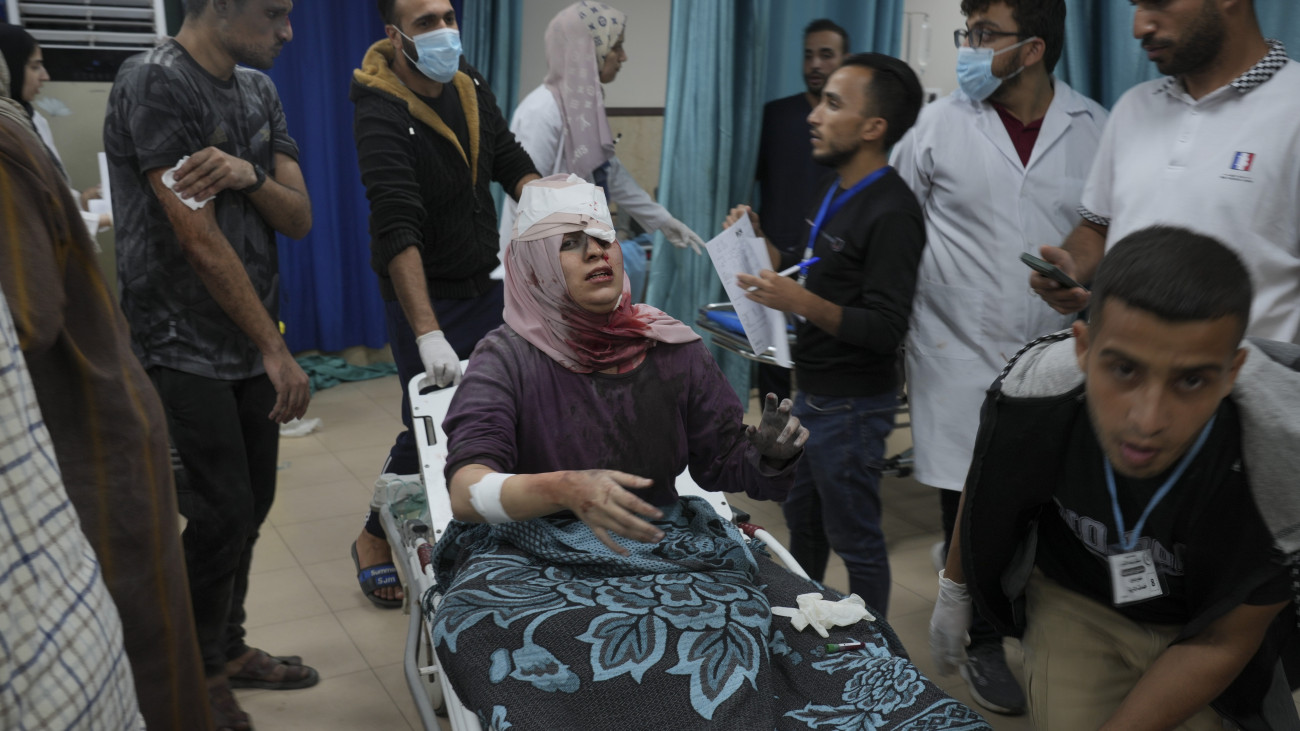 Izraeli légicsapásban megsebesült palesztin nővel érkeznek kórházba a Gázai övezet középső részén fekvő Deir al-Balahban 2023. október 21-én. A Gázai övezetet irányító Hamász palesztin iszlamista terrorszervezet október 7-én betört az övezet melletti izraeli településekre, ahol meggyilkoltak több mint 1400 embert, háromezret megsebesítettek és elhurcoltak kétszáz civilt. A Hamász elleni izraeli hadművelet eddig közel 3800 palesztin halálát okozta a Gázai övezetben, a sebesültek száma meghaladja a 12 ezret.