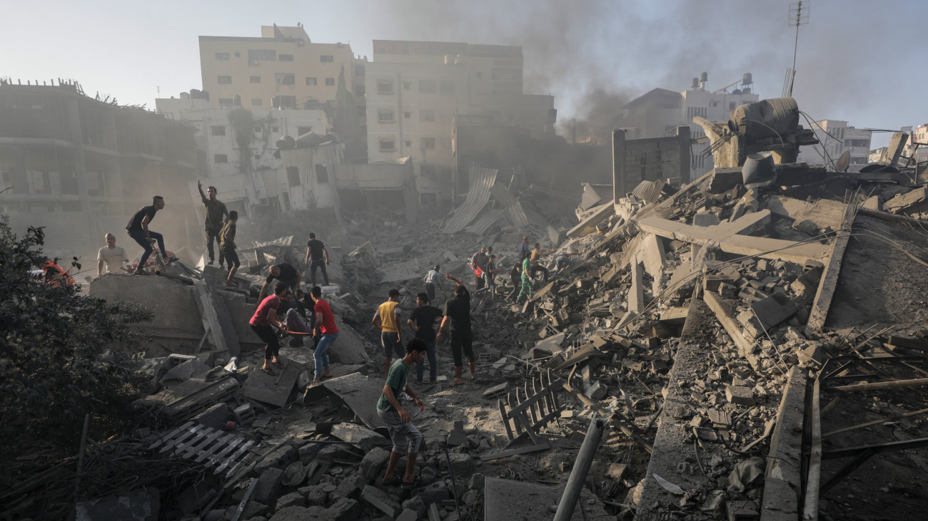 Izraeli légitámadásban összedőlt ház romjai között keresnek túlélőket palesztinok Gázában 2023. október 25-én. A Gázai övezetet irányító Hamász palesztin iszlamista szervezet október 7-én többfrontos támadást indított Izrael ellen, az izraeli légierő azóta támadja a Hamász katonai létesítményeit a palesztinok lakta övezetben. Izraelben több mint 1400 ember életét vesztete, az izraeli válaszcsapások mintegy 5800 palesztin halálát okozták a Gázai övezetben.