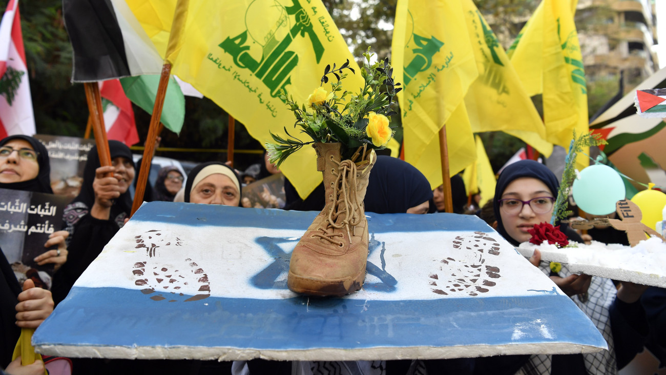 A Hezbollah libanoni síita fegyveres mozgalom támogatói izraeli zászlót taposó cipővel tüntetnek a palesztinokat támogató tüntetésükön, Bejrútban 2023. október 27-én. A Gázai övezetet uraló Hamász fegyveresei október 7-én meglepetésszerű támadást indítottak Izrael ellen, betörtek az ország déli részébe, több mint 1400 embert meggyilkoltak, további mintegy háromezret megsebesítettek, valamint mintegy 200 embert elraboltak és túszként tartanak fogva. A gázai egészségügyi hatóságok szerint az izraeli válaszcsapásokban azóta már több mint 7300 ember halt meg a Gázai övezetben, a sebesültek száma pedig 19 ezerhez közelít.