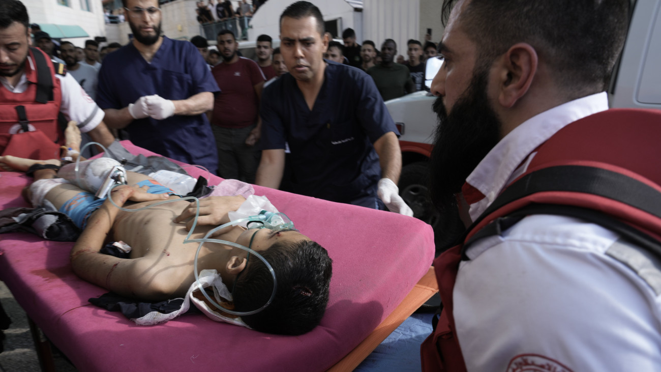 Sebesült palesztin fiúval érkeznek kórházba a ciszjordániai Tulkaremben, miután izraeli támadás érte a Núr es-Samsz palesztin menekülttábort 2023. október 19-én. A Gázai övezetet irányító Hamász palesztin iszlamista terrorszervezet október 7-én betört az övezet melletti izraeli településekre, ahol megöltek több mint 1400 embert, háromezret megsebesítettek és elhurcoltak mintegy kétszáz civilt. A Hamász elleni izraeli hadművelet eddig közel 3500 palesztin halálát okozta a Gázai övezetben, a sebesültek száma már a 12 ezret is átlépte.