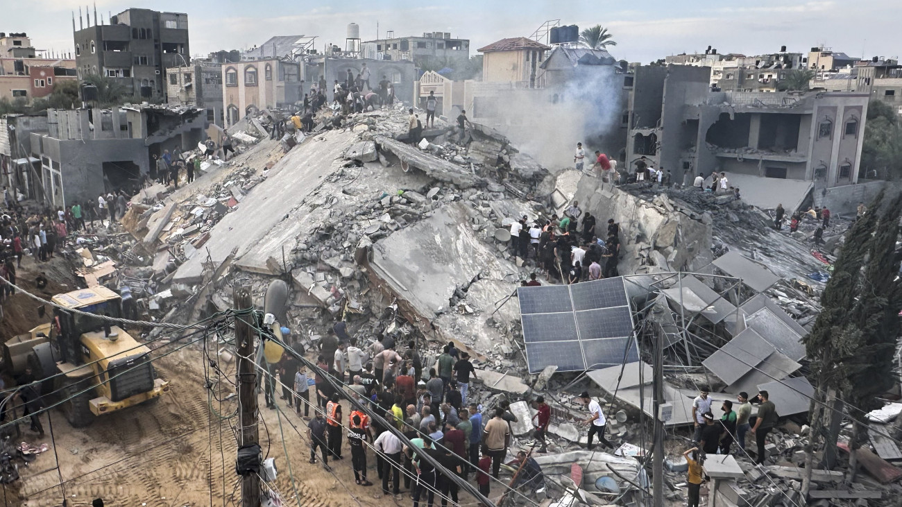 Izraeli légitámadásban lerombolt ház romjai között keresnek túlélőket palesztinok a Gázai övezet középső részén fekvő Nuszeirat palesztin menekülttáborban 2023. október 31-én. A Gázai övezetet irányító Hamász palesztin iszlamista szervezet október 7-én többfrontos támadást indított Izrael ellen, az izraeli légierő azóta támadja a Hamász katonai létesítményeit a palesztinok lakta övezetben. Izraelben több mint 1400 ember életét vesztette, az izraeli válaszcsapások több mint 8300 palesztin halálát okozták a Gázai övezetben.