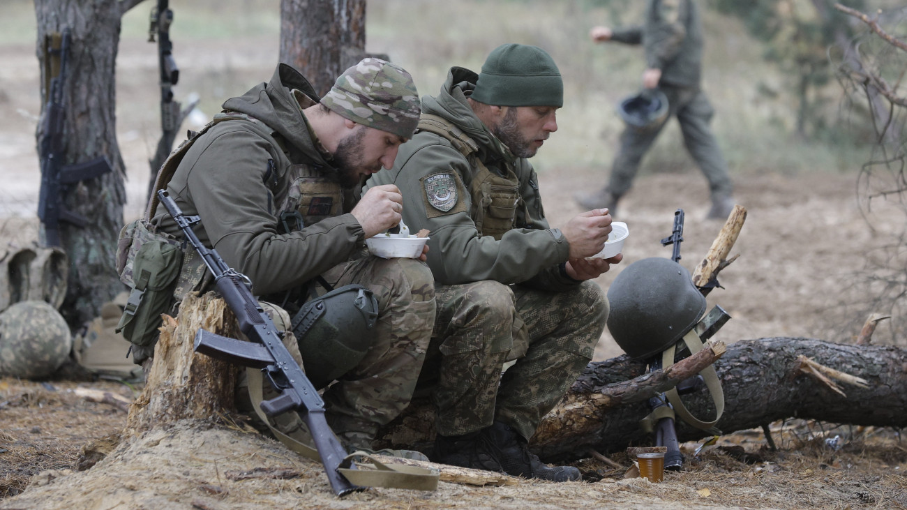 A Burevij (Hurikán) ukrán rohamdandár katonái ebédszünetet tartanak az egység frontszolgálatot megelőző kiképzése közben egy Kijev környéki gyakorlótéren 2023. november 1-jén, az Ukrajna elleni orosz háború alatt.